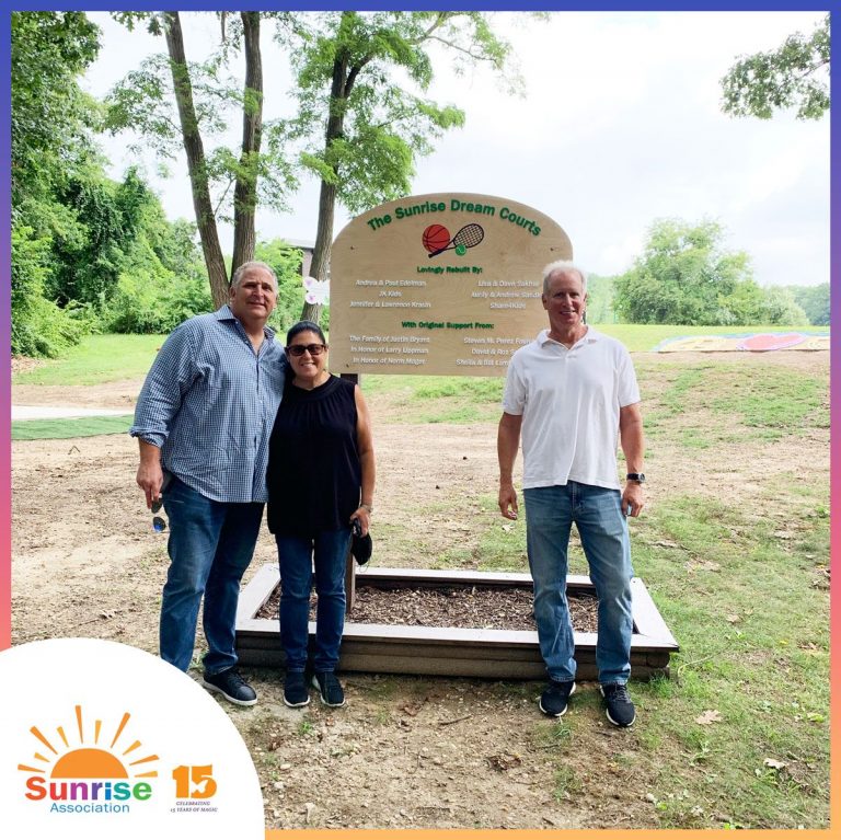 Lawyers standing by The Sunrise Dream Courts Sign