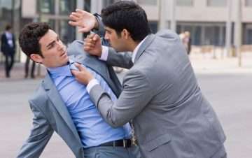Man in gray suit holding gray suit and blue dress shirt by the collar, punitive damages possible.