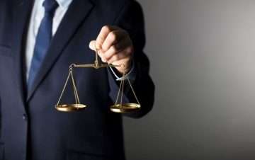 Man in suit holding golden scale