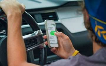 Man looking at phone while driving