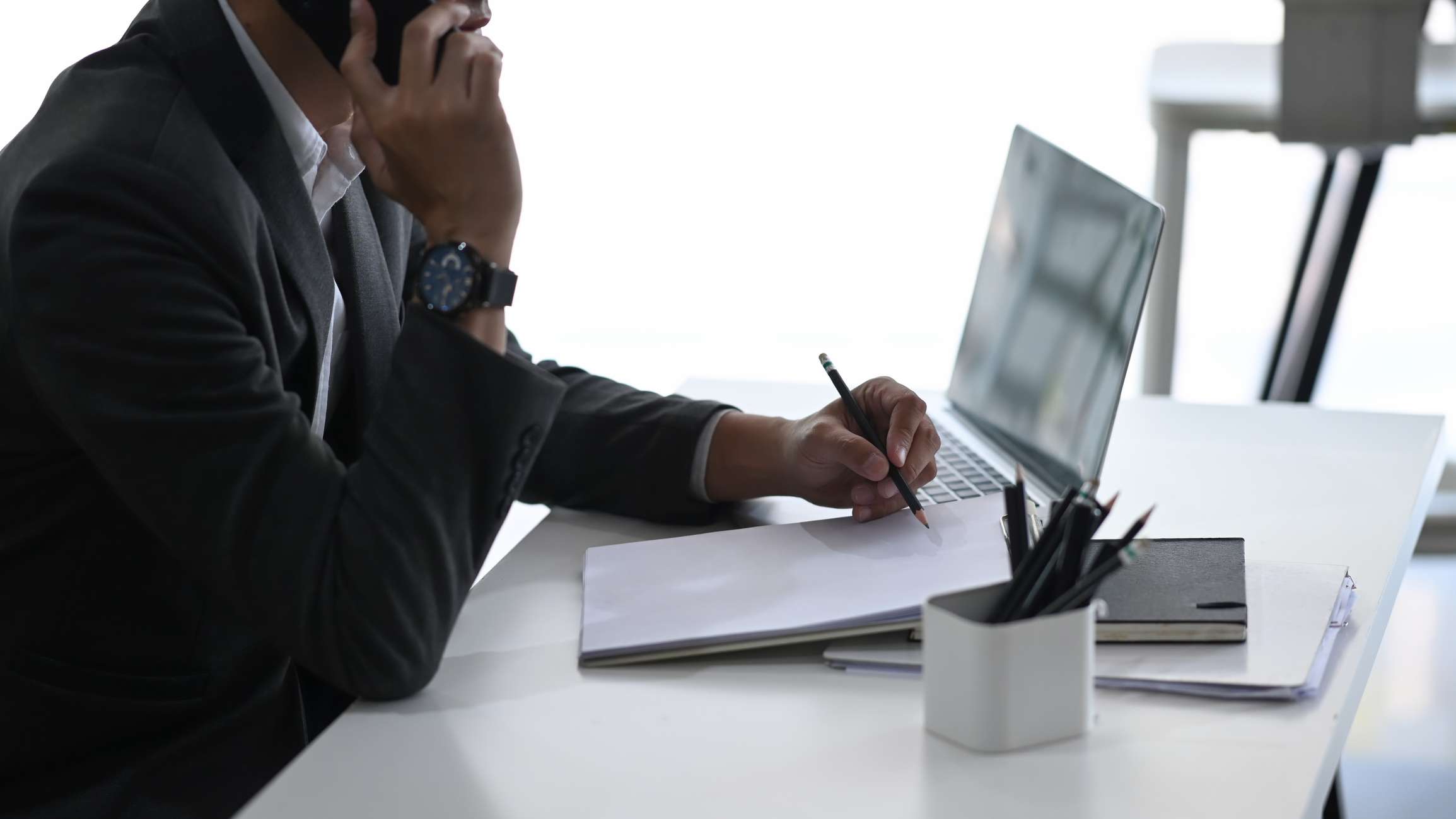 Man at desk with pen and paper and computer at desk. We explain 5 common mistakes to avoid during your personal injury case.