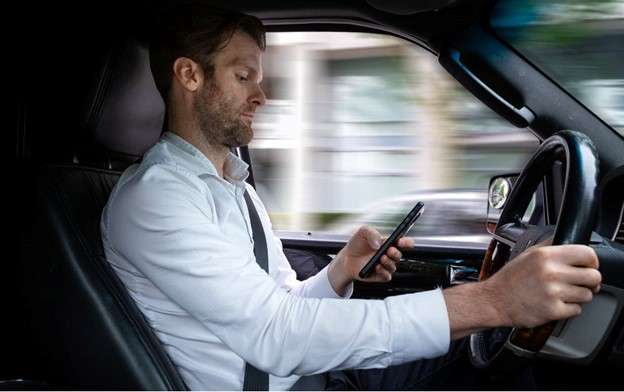 Man driving while on his phone. There are many signs indicating that the driver was distracted during an accident.