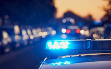 Police Officer driving with their sirens on, warrant.