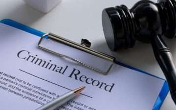 Criminal Record sheet on clipboard, pencil resting on top. Criminal Charges.