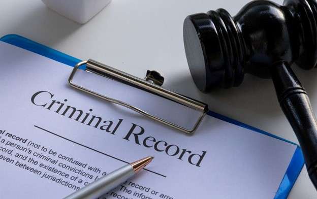 Criminal Record sheet on clipboard, pencil resting on top. Criminal Charges.