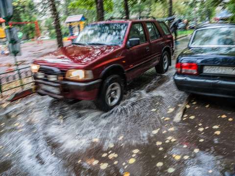 Moving shot of two cars driving in the rain.